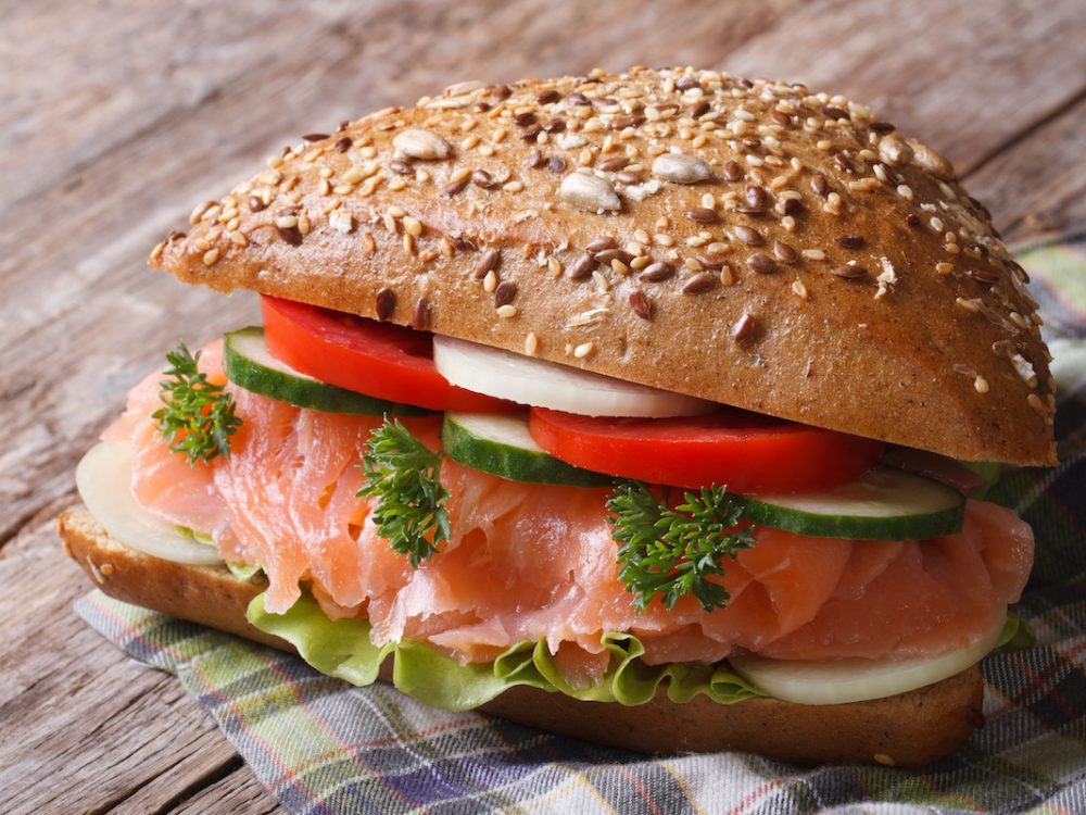 Delicious sandwich with salmon and vegetables close up